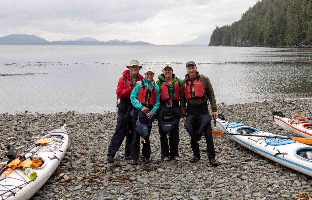 Group sea kayaking tour, North Vancouver Island, British Columbia. Group on a beach during lunch.