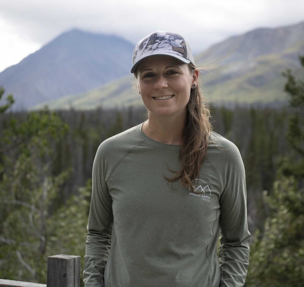 Pam McGarel, Founder and CEO of Mosaic Earth Travel, poses infront of scenic view.